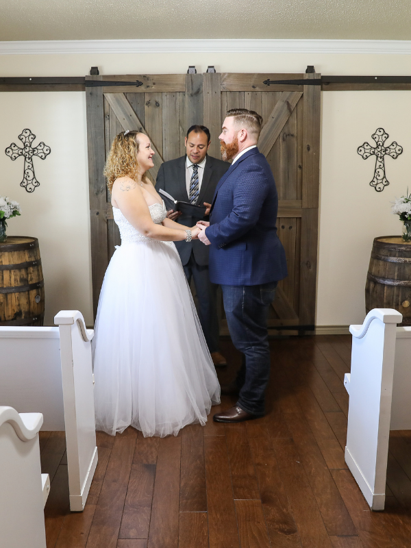 Everlasting Elopements couple standing and holding hands in front of double doors during their ceremony at Everlasting Elopements Chapel