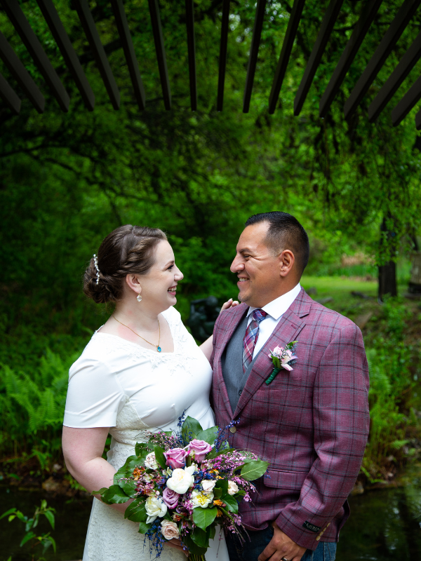 Everlasting Elopements couple smiling at each other in front of greenery at Umlauf Sculpture Garden