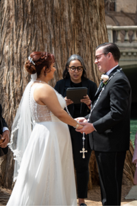 Everlasting Elopements couple during their ceremony with Minister Paola Fernandez at Marriage Island on the San Antonio Riverwalk Everlasting Elopements couple standing and holding hands during their ceremony in front of Minister Paola Fernandez at Marriage Island on the San Antonio Riverwalk